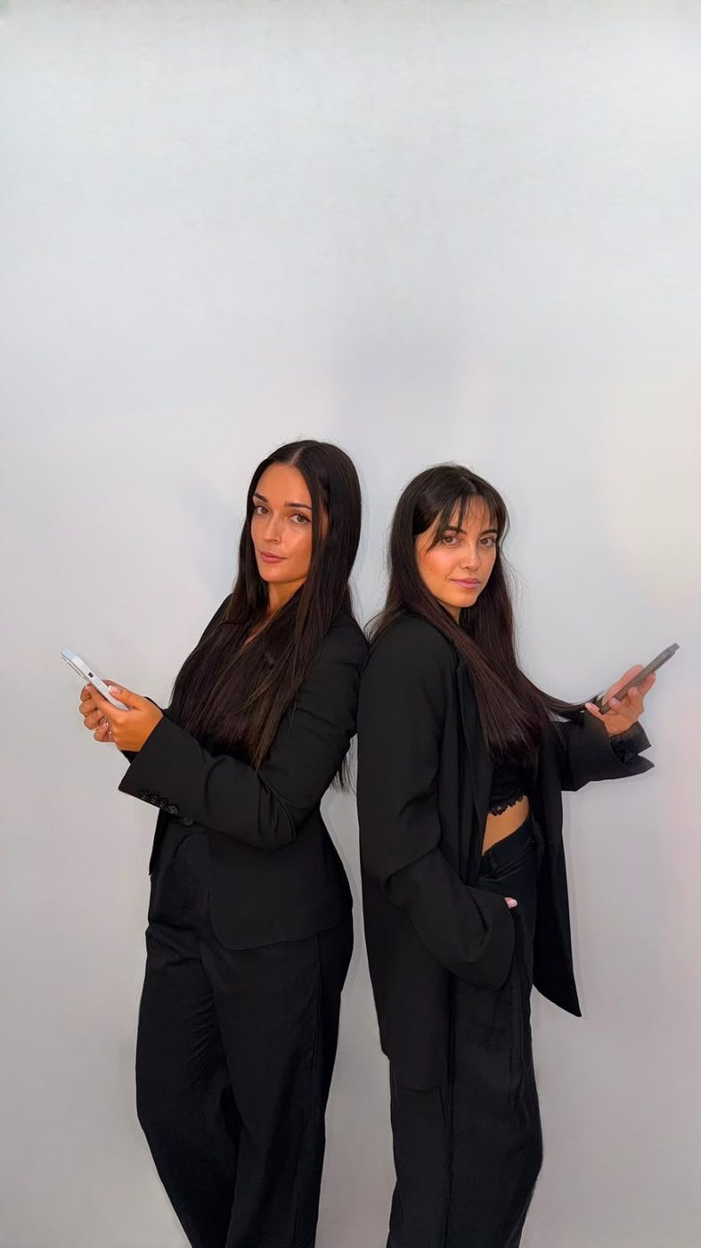 Alba y Raquel de espaldas con sus móviles